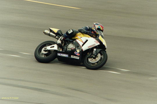 Black and yellow bike, outside shot of turn one